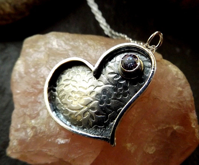 Silver heart necklace with purple cz and flower textured background