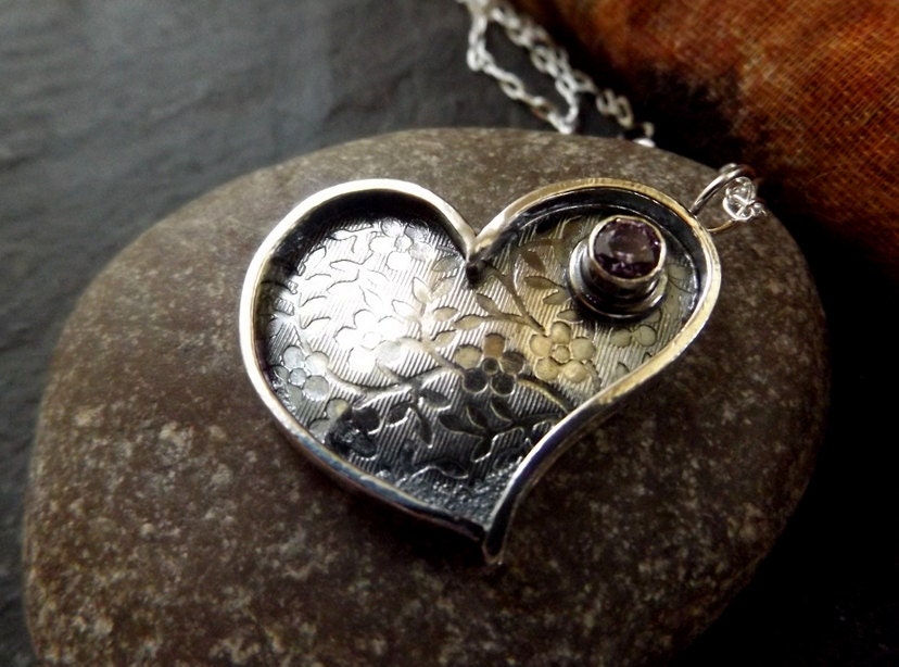Silver heart necklace with purple cz and flower textured background