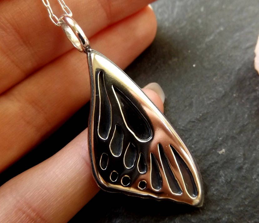 Silver Butterfly wing necklace pendant with oxidized background
