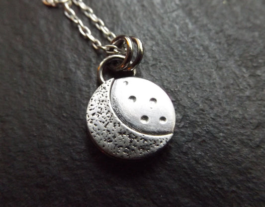 Silver crescent moon necklace with textured background and brushed polished finish , small moon pendant